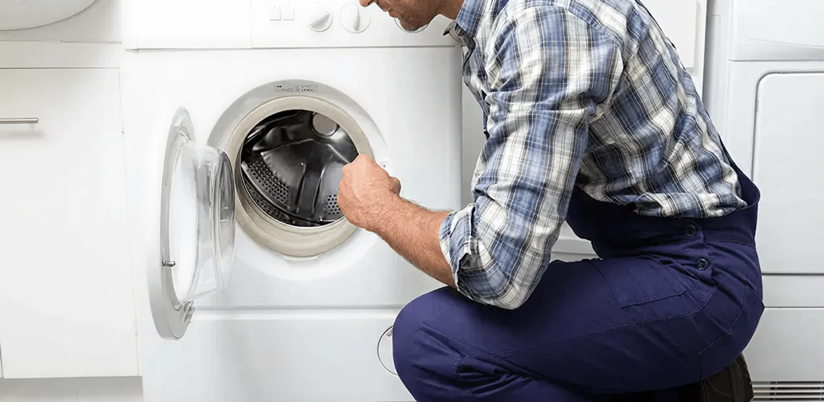 Handyman inspecting a dryer drum and internal parts for repair in Oakland, CA